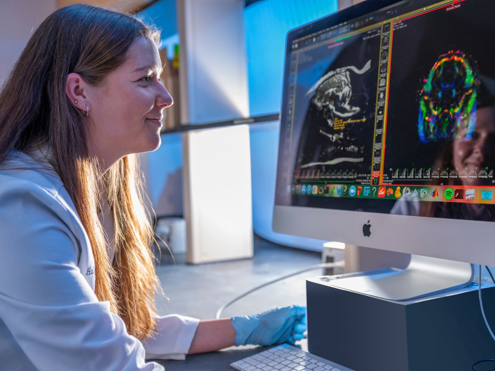 A scientist reviewing brain scans on a computer screen.